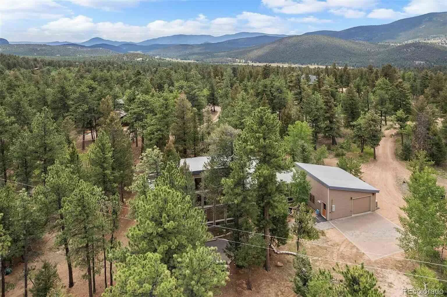 Aerial view of the wooded property, house and garage