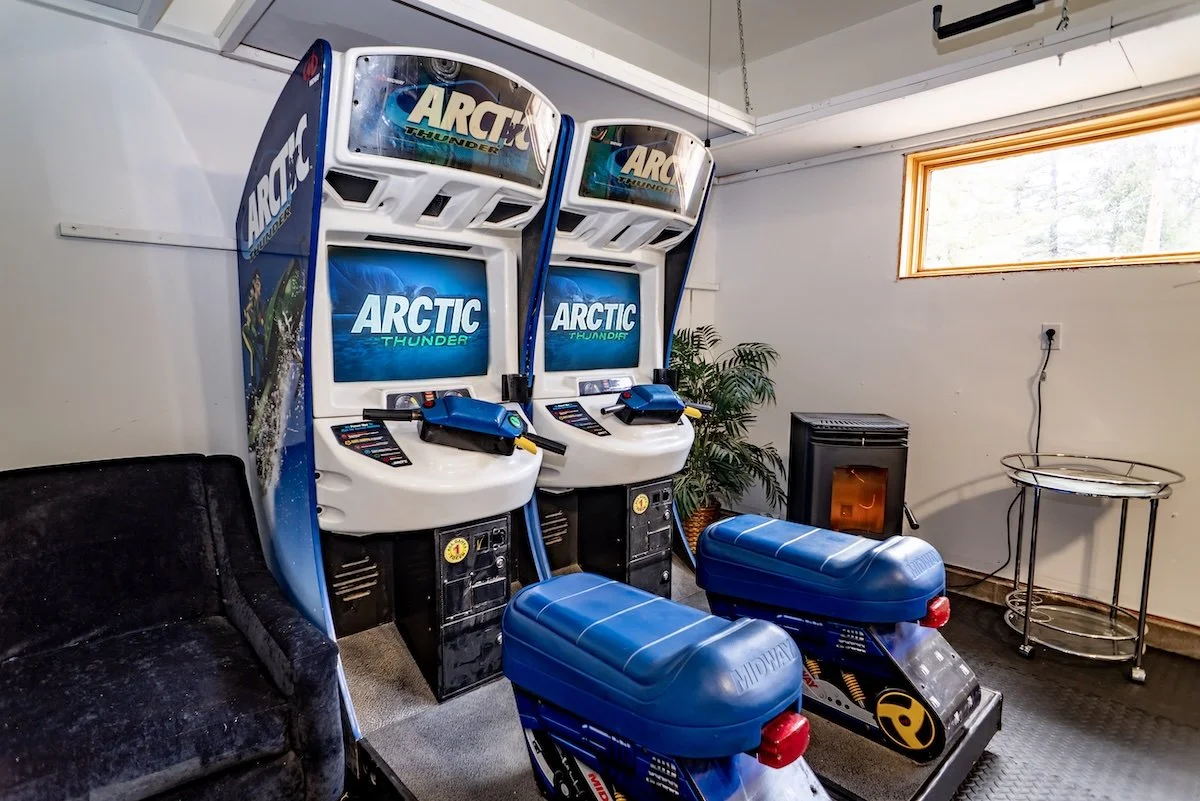 Two linked Arctic Thunder racing arcade machines with blue ride seats