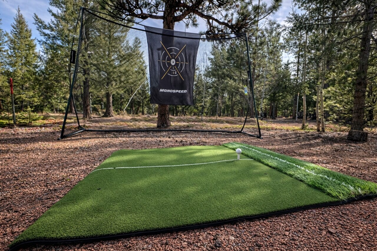 Private golf practice mat and hitting net in the forest
