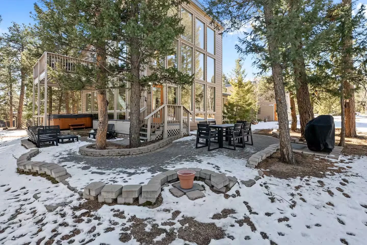 Paver patio with hot tub and outdoor furniture with snow on the ground