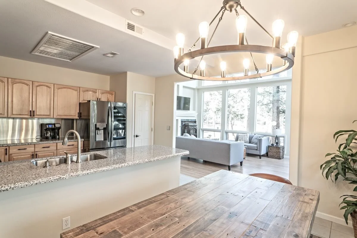 Open kitchen and dining with chandelier and wooden table