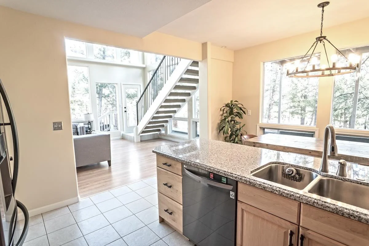 Kitchen island with sink looking into the bright living space