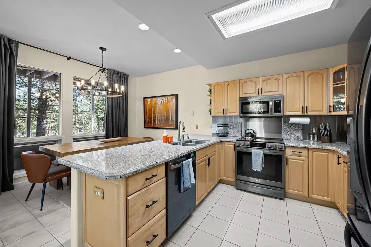 Kitchen with light wood cabinets, stainless appliances and granite counters
