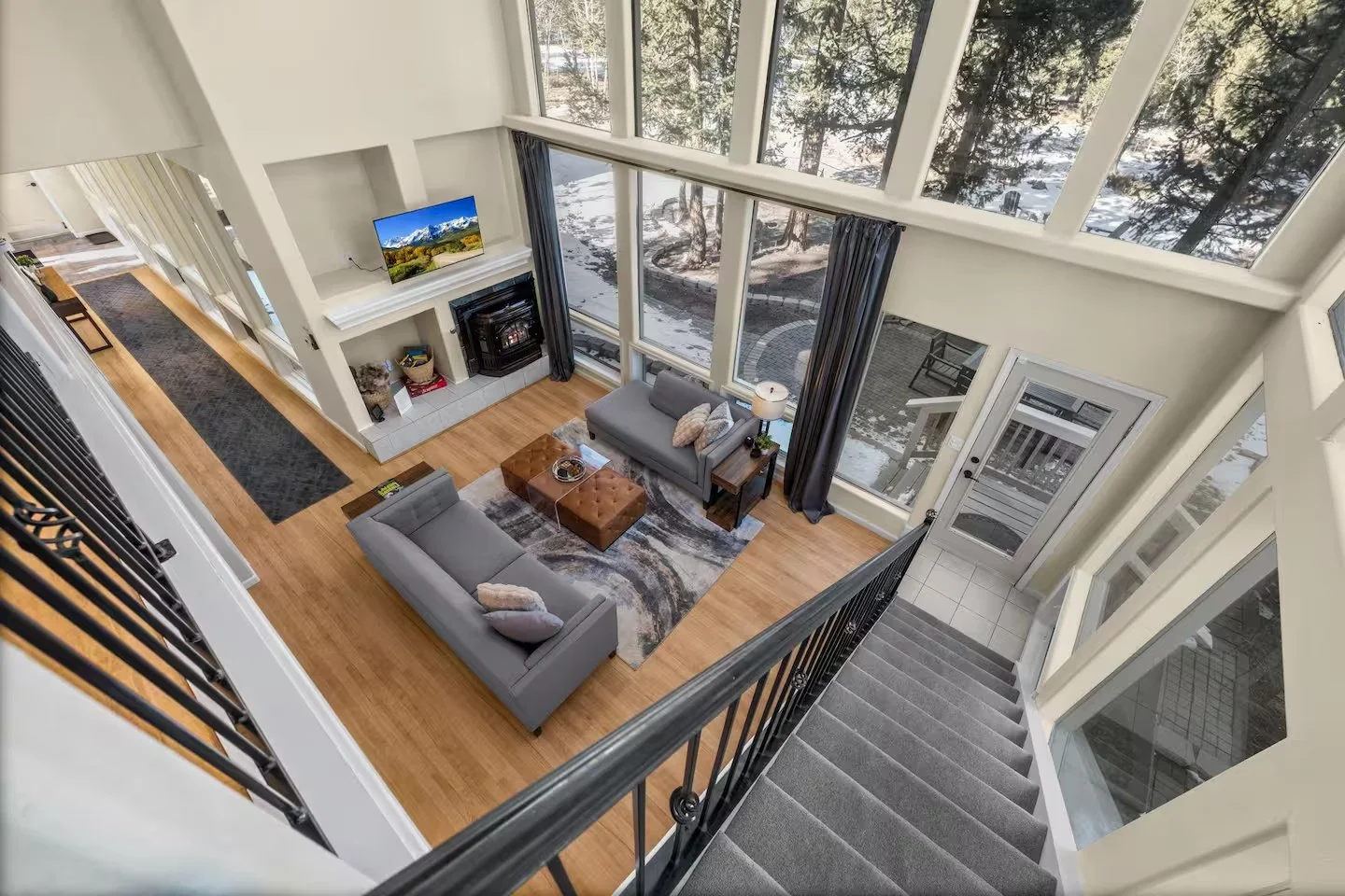 Living room opening to an outdoor deck, television above the fireplace