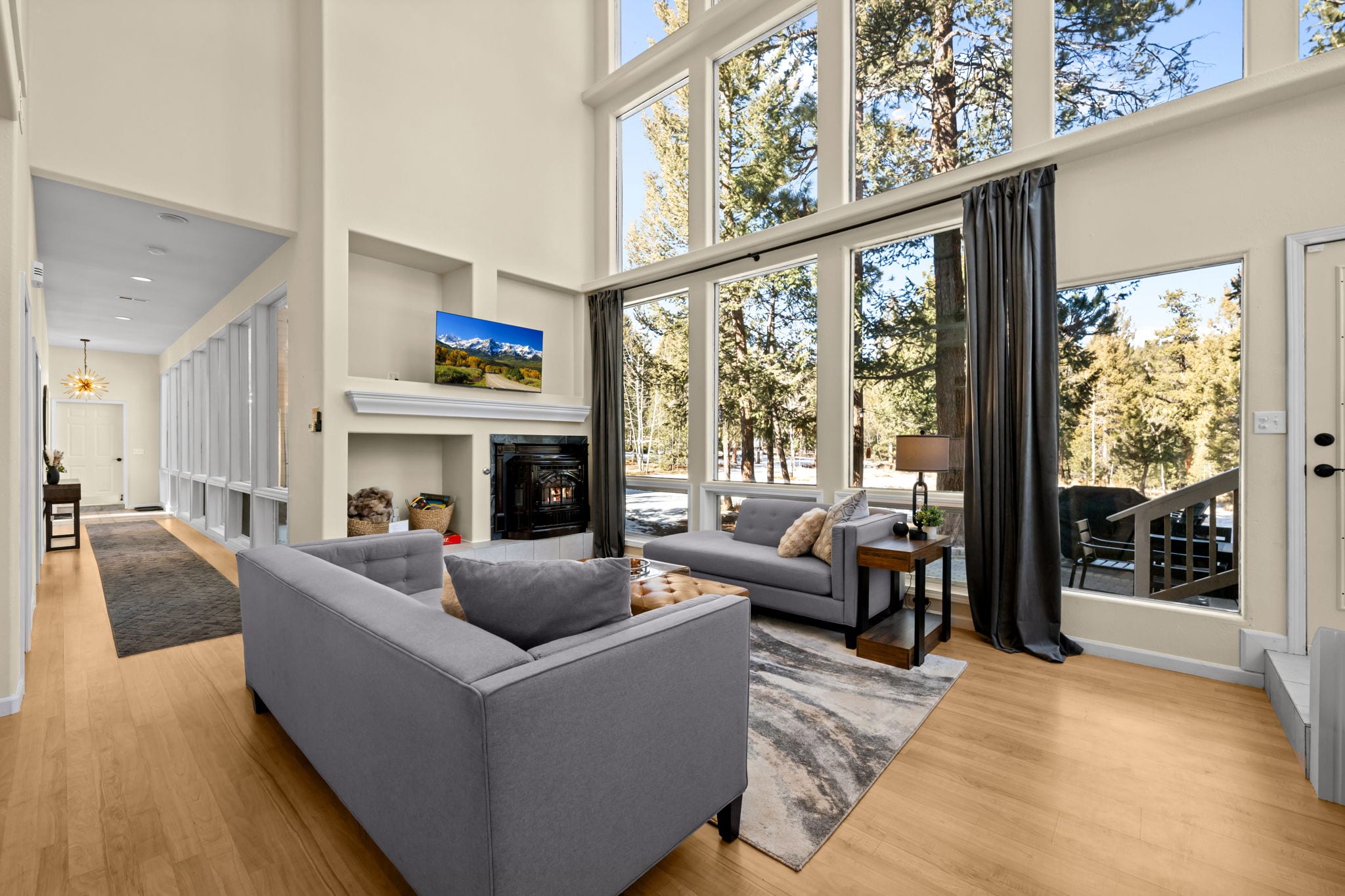 Living room viewed from the bright window-lined hallway