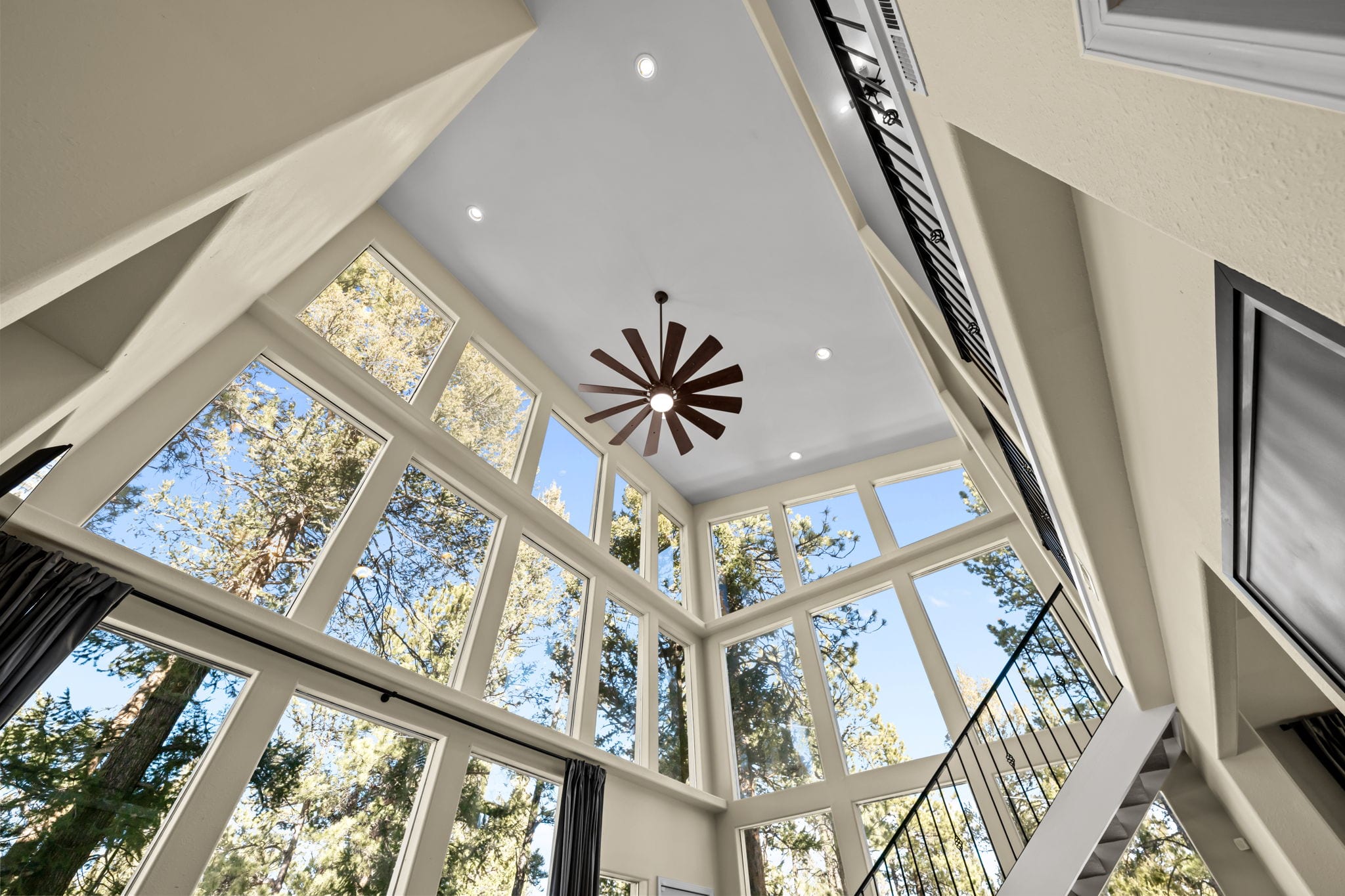 Two-story living room windows looking into the surrounding forest