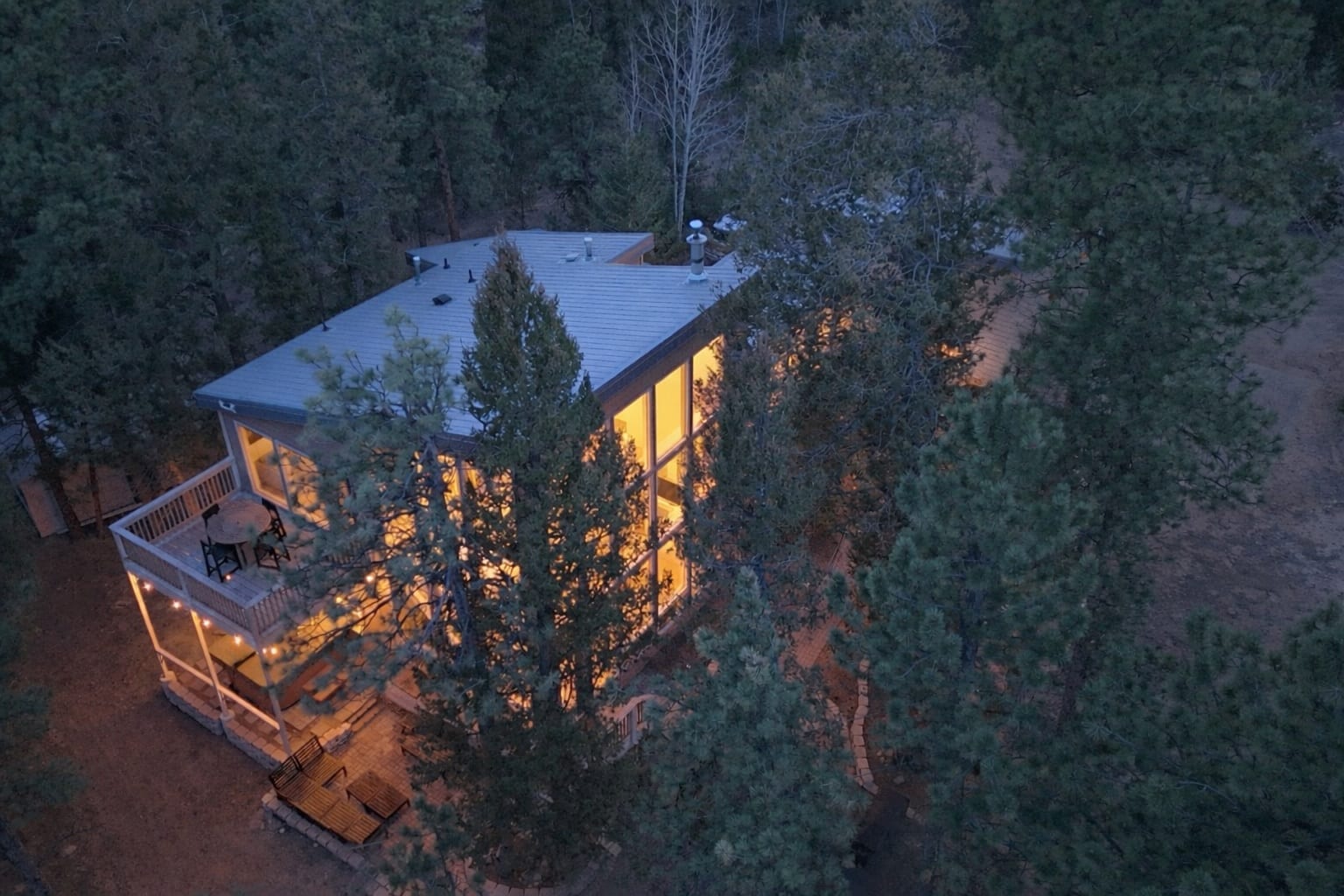 Evening exterior of The Stillwood Retreat with warm interior lights